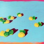 A painting of scattered pineapple lollies on a blue background.